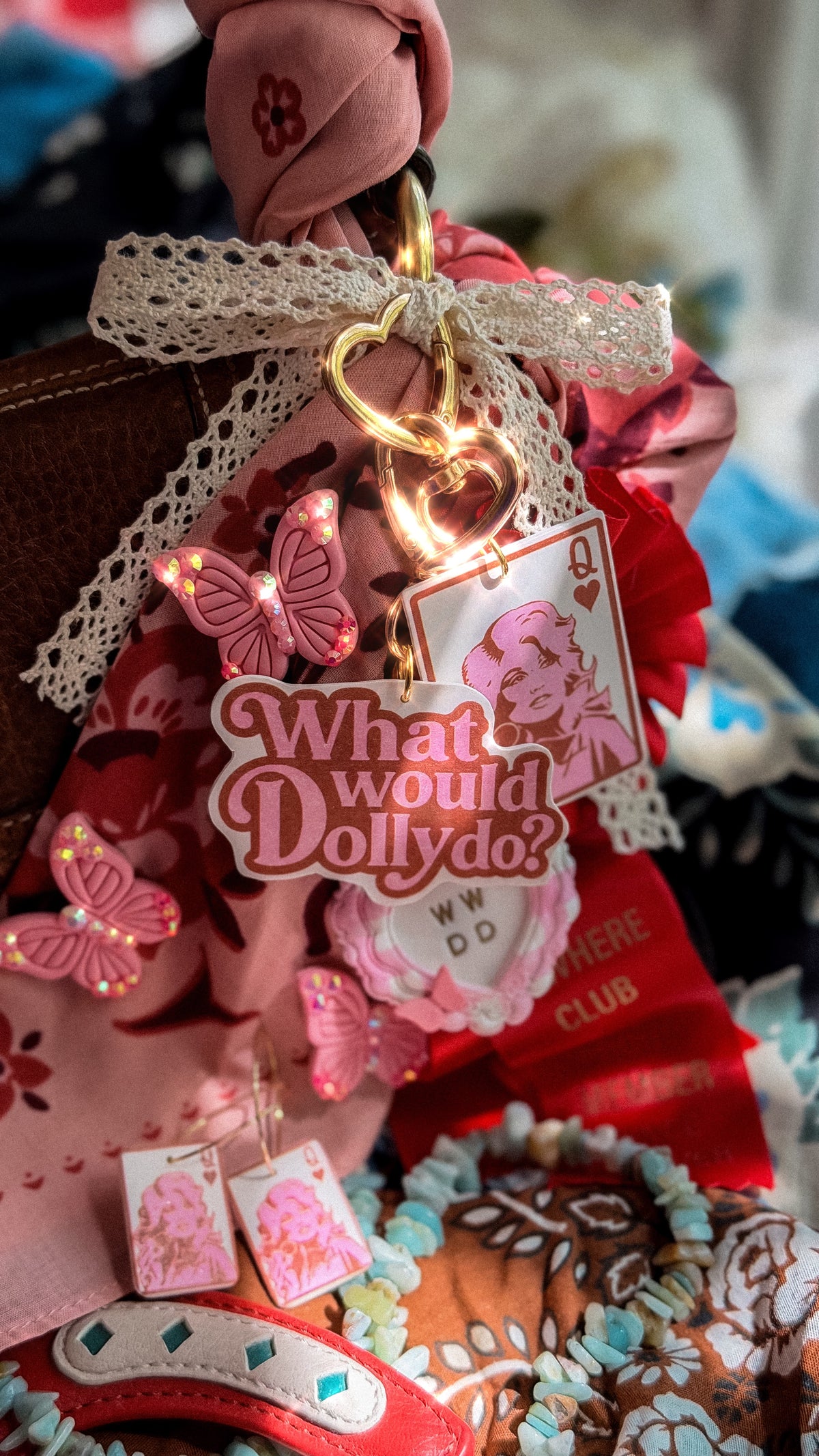 Pink rhinestone butterfly pin styled with Queen Dolly card charm, What Would Dolly Do charm and lace ribbon