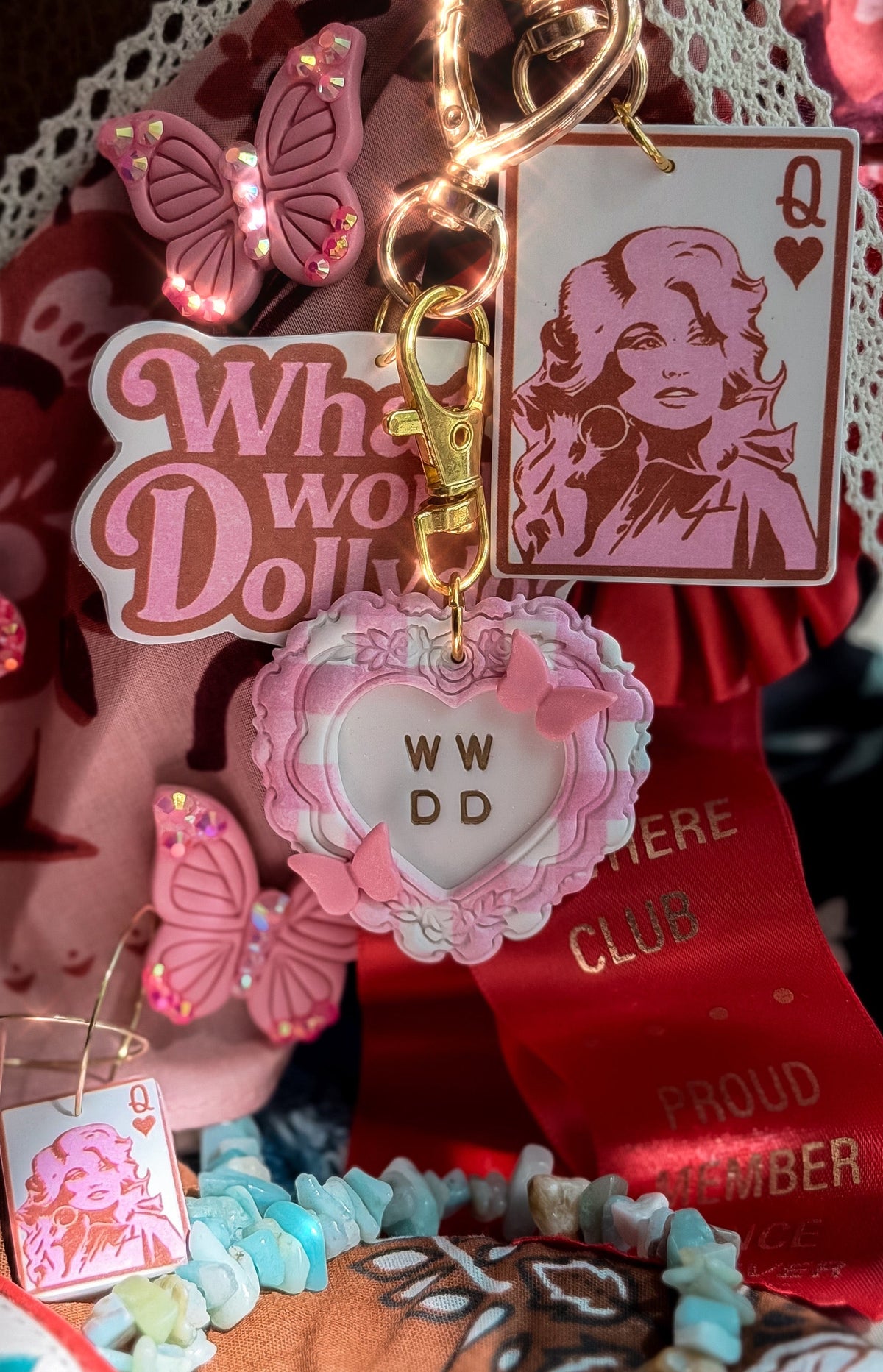 What Would Dolly Do pink heart bag charm with butterfly accents styled with Queen Dolly card charm and rhinestone butterflies