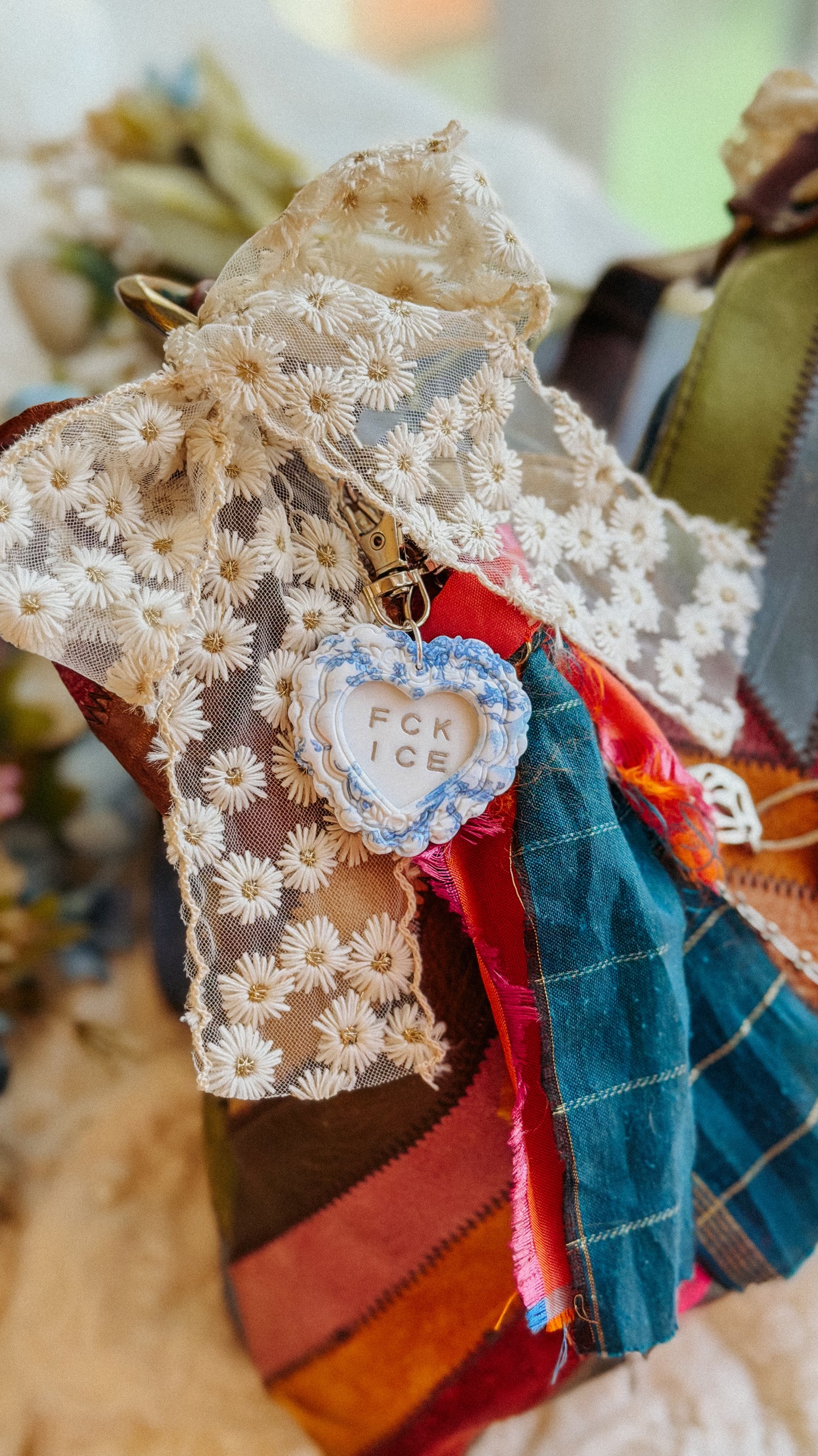 Close-up of silver chinoiserie heart keychain with FCK ICE message — handmade polymer clay keychain with detailed floral texture and glossy finish.