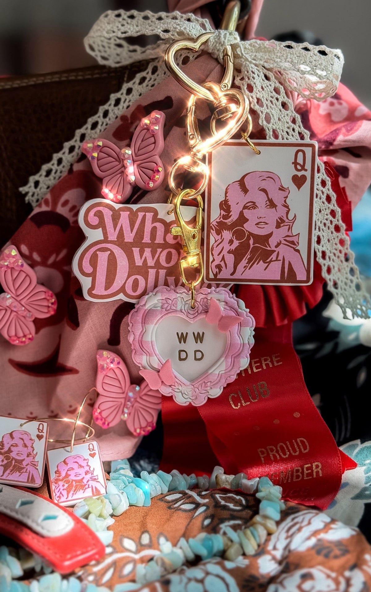 Pink WWDD heart keychain with gold clasp, lace ribbon, Queen Dolly charm and butterfly accessories