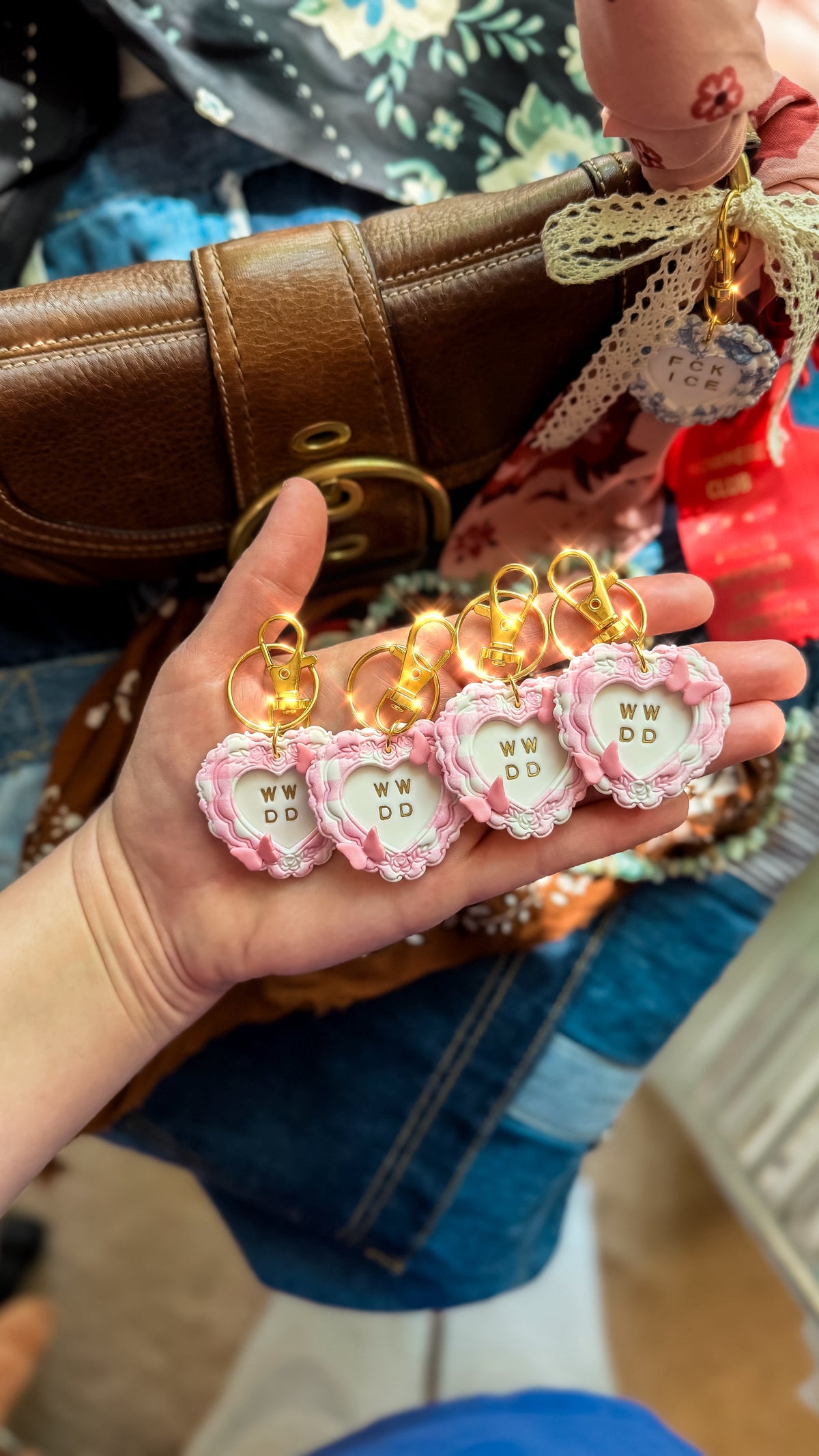 Four pink What Would Dolly Do heart bag charms and keychains with butterfly details and gold clasps