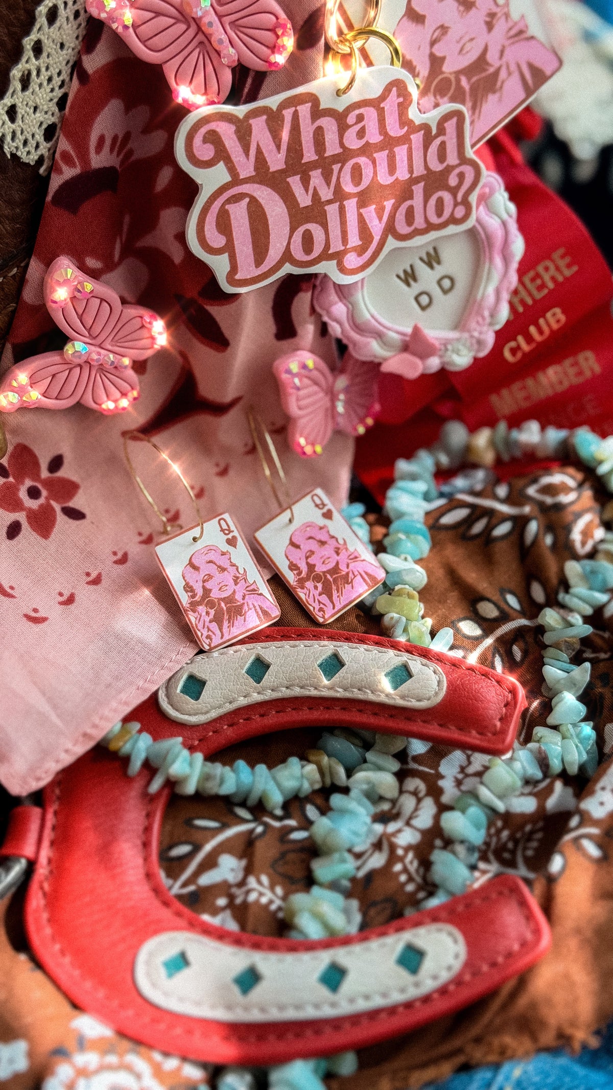 Dolly Parton inspired Queen of Hearts earrings styled with pink bag charms, western accessories and turquoise jewelry