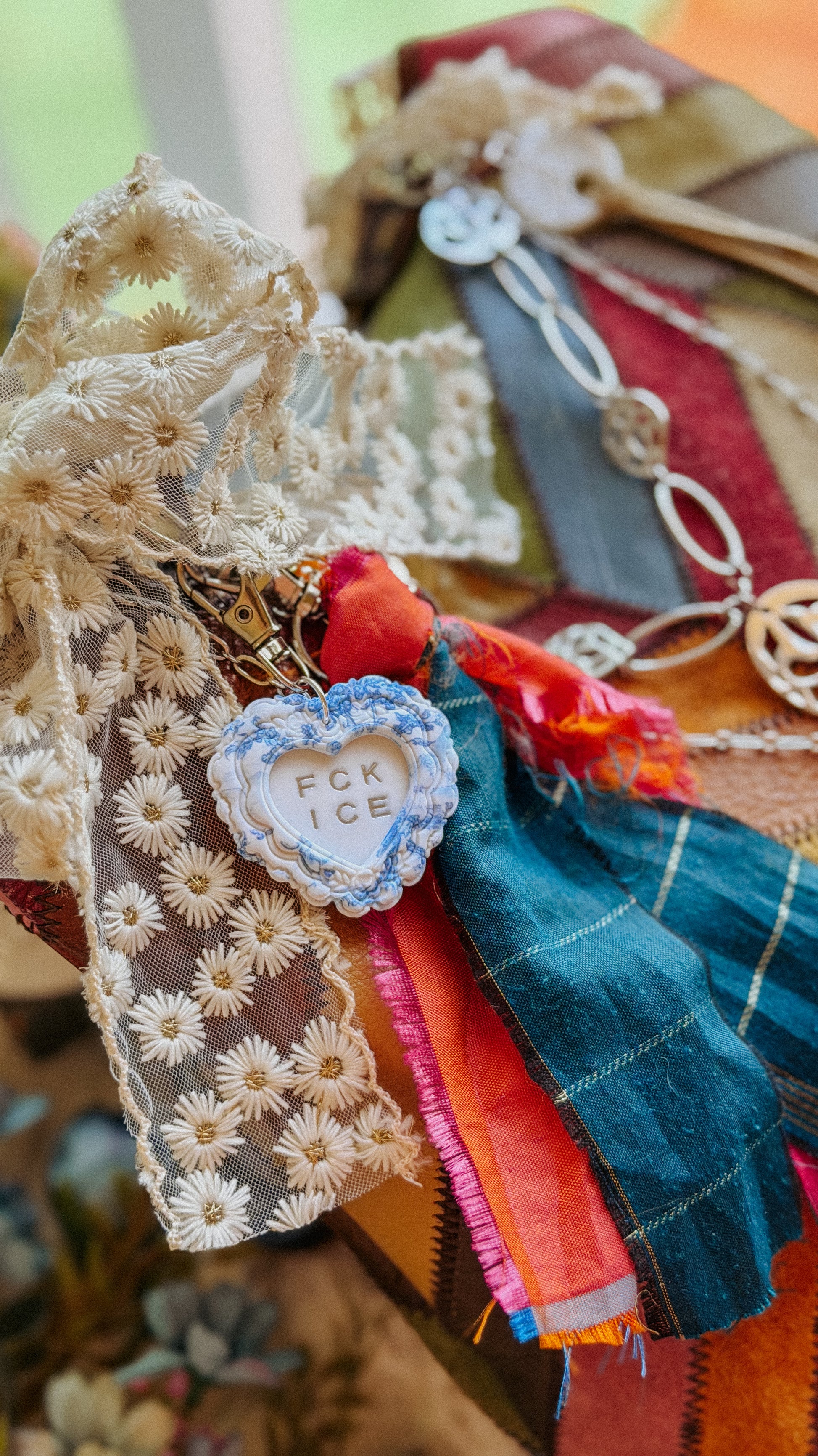Handmade FCK ICE chinoiserie heart keychain in silver with blue floral detail and gold hardware — polymer clay statement bag charm, activist gift accessory.