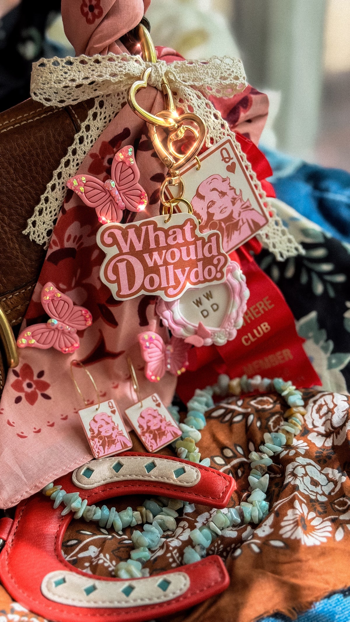 Sparkly pink butterfly brooch styled with Dolly Collection bag charms, Queen Dolly earrings and western accessories